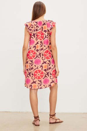 A person with long hair is wearing a JENNA PRINTED SILK COTTON VOILE DRESS by Velvet by Graham & Spencer. They are standing with their back facing the camera.