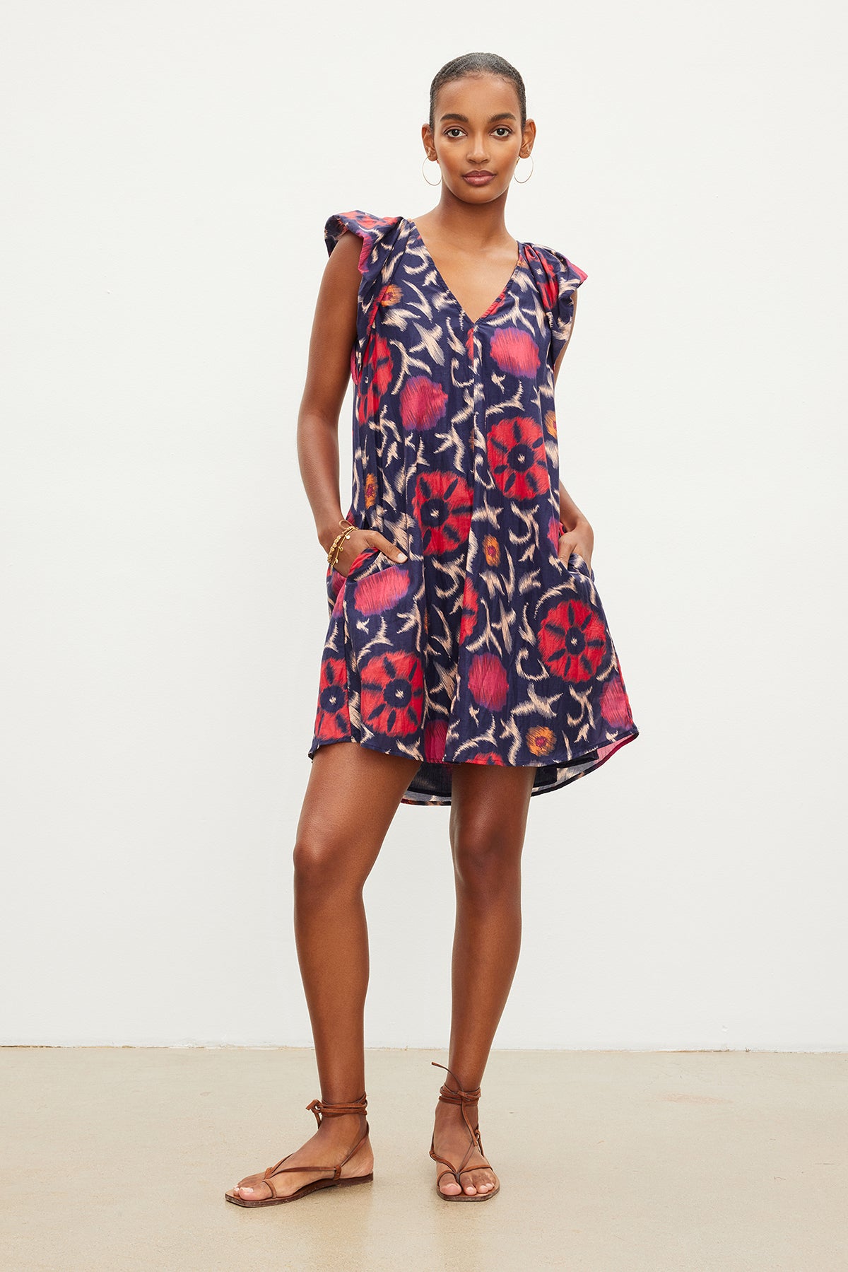 The model is wearing a Jenna Printed Silk Cotton Voile Dress by Velvet by Graham & Spencer with a ruffled sleeve.