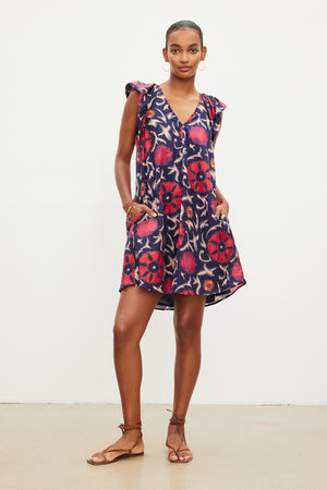 The model is wearing a Jenna Printed Silk Cotton Voile Dress by Velvet by Graham & Spencer with a ruffled sleeve.