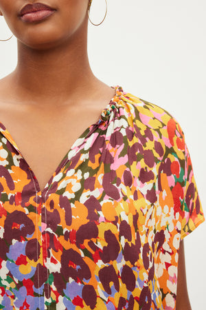 A woman wearing a Velvet by Graham & Spencer TRIXY PRINTED COCOON TOP with a v - neck.