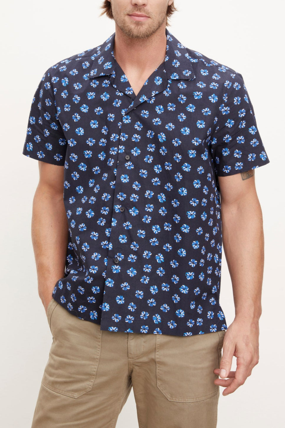 Man wearing a short-sleeved patterned Iggy button-up shirt by Velvet by Graham & Spencer and khaki pants standing against a plain background.-36009928229057