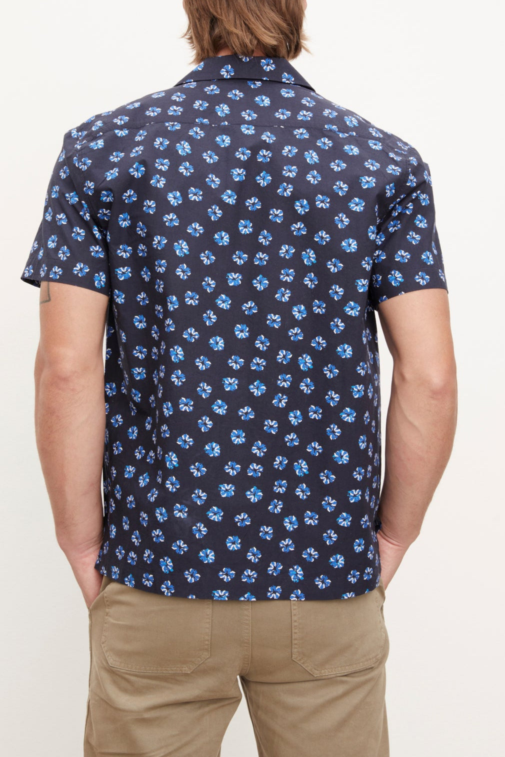 Man standing with his back to the camera, sporting a blue Iggy button-up shirt by Velvet by Graham & Spencer and khaki relaxed fit pants.-36009928294593