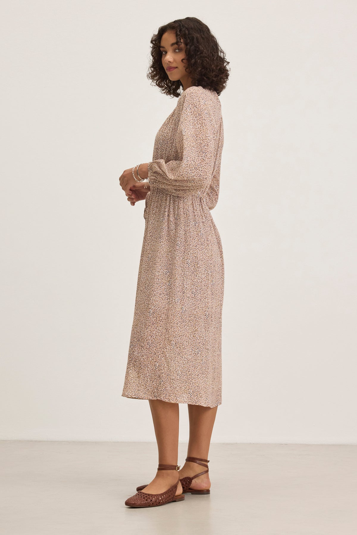 A person with curly hair is wearing the LIMA PRINTED CRINKLE COTTON GAUZE DRESS by Velvet by Graham & Spencer and brown shoes, standing against a plain background.-38820676370625