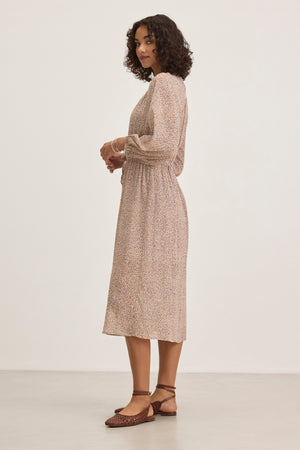 A person with curly hair is wearing the LIMA PRINTED CRINKLE COTTON GAUZE DRESS by Velvet by Graham & Spencer and brown shoes, standing against a plain background.