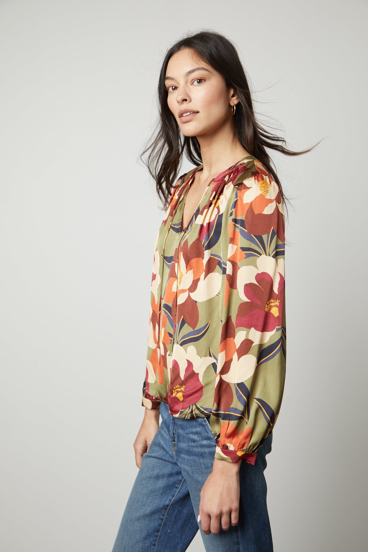 The model is wearing an ISRA PRINTED V-NECK BLOUSE from Velvet by Graham & Spencer, creating a timeless look.-26914817802433
