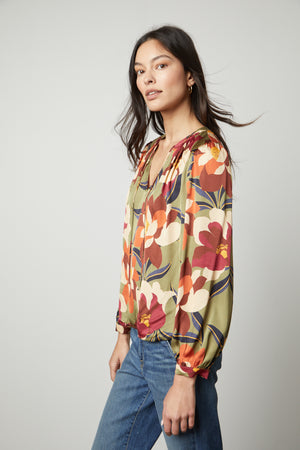 The model is wearing an ISRA PRINTED V-NECK BLOUSE from Velvet by Graham & Spencer, creating a timeless look.