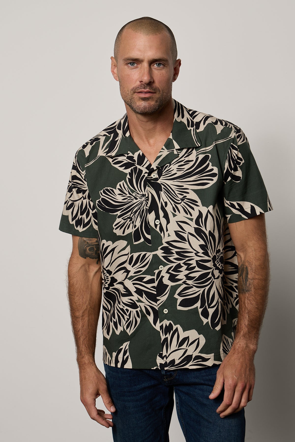 Iggy Button-Up Shirt in Catalina print with large bold black and cream abstract flower print on dark green background, with dark blue denim front