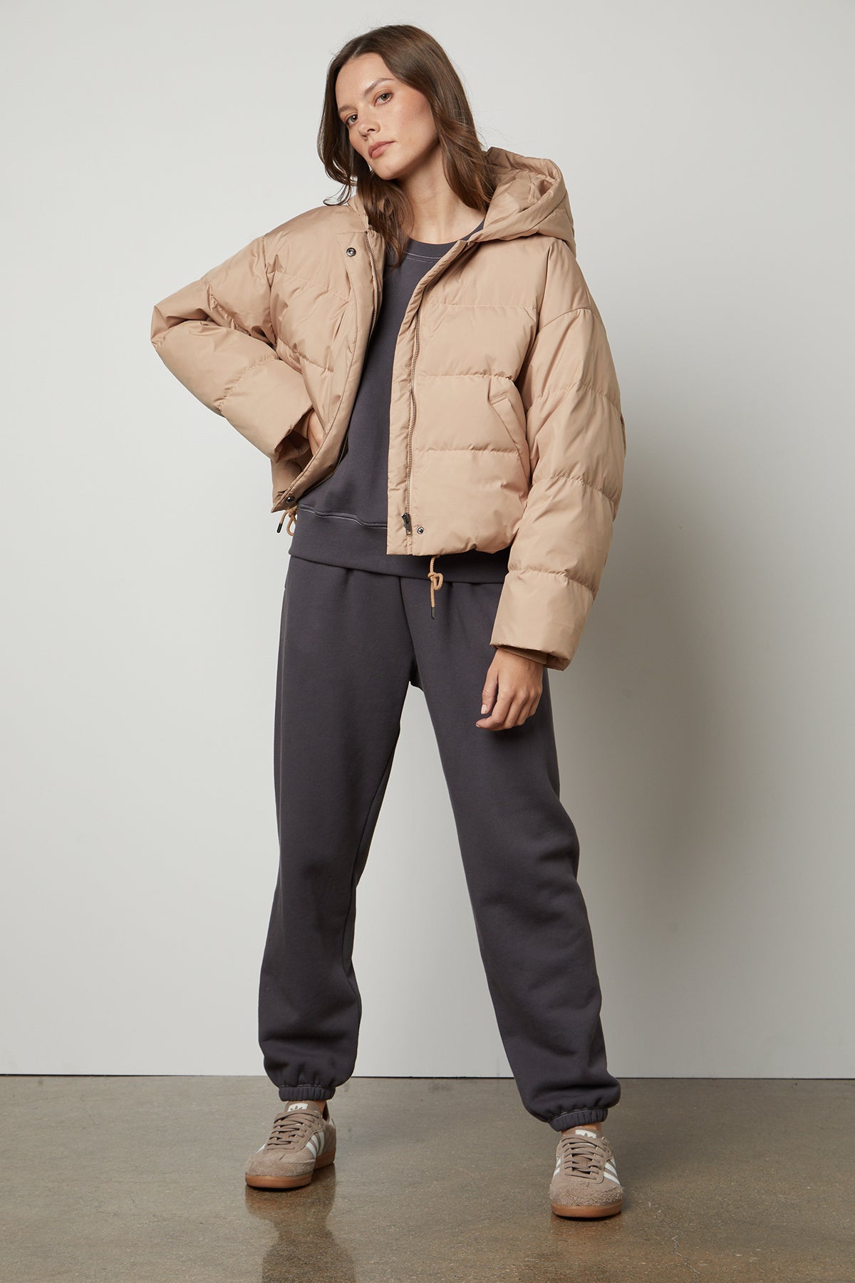 The model is wearing a cozy beige OLIA PUFF SLEEVE SWEATSHIRT by Velvet by Graham & Spencer.-35445661565121