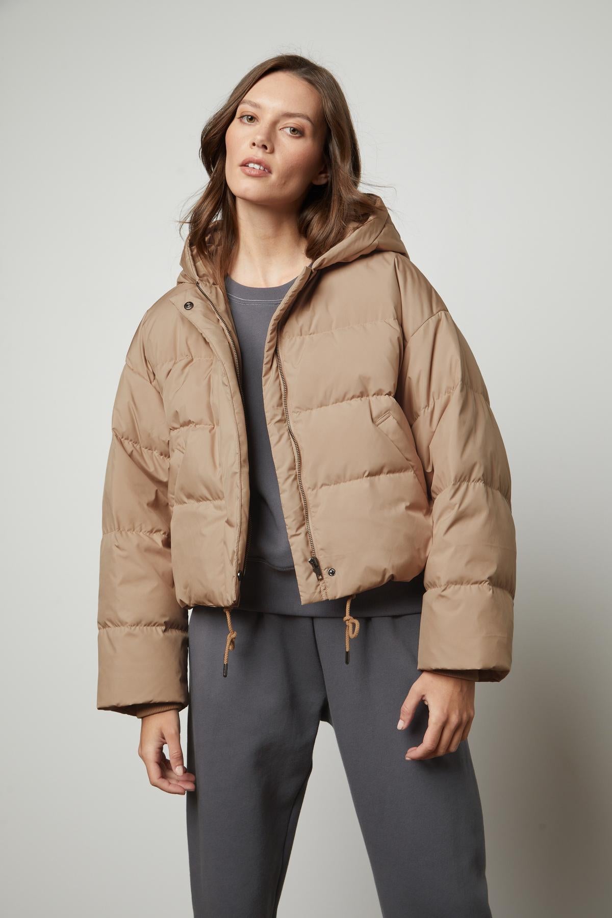 A woman wearing a Velvet by Graham & Spencer RAYLIN CROPPED PUFFER JACKET.