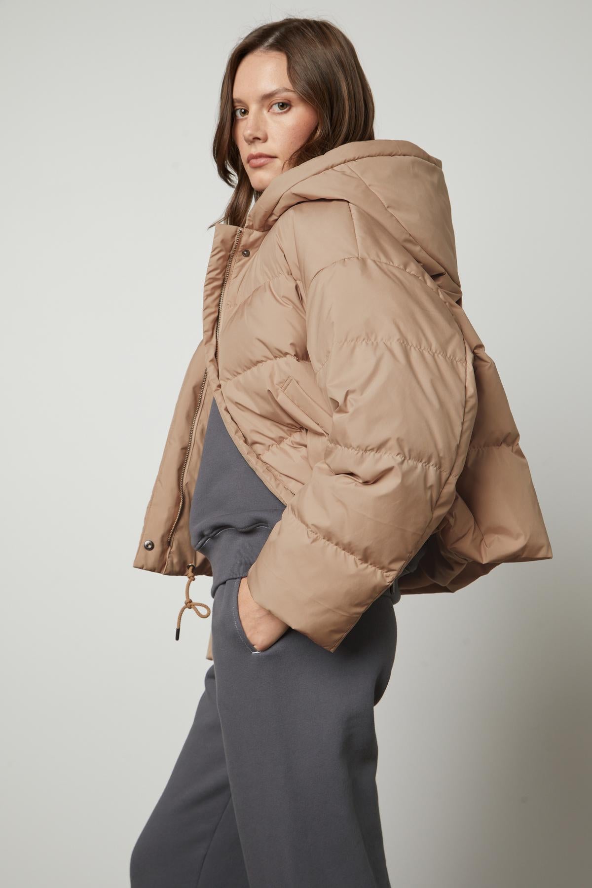 A model wearing the Velvet by Graham & Spencer RAYLIN CROPPED PUFFER JACKET and grey sweatpants.-26910089740481