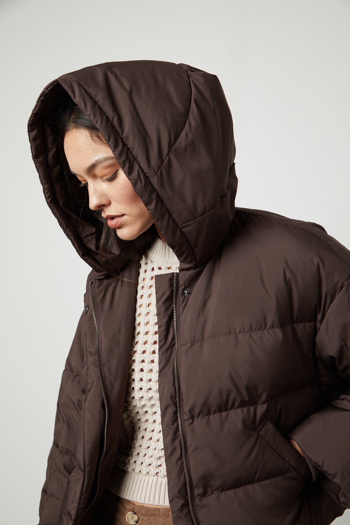 A woman wearing a Velvet by Graham & Spencer RAYLIN CROPPED PUFFER JACKET with hood.