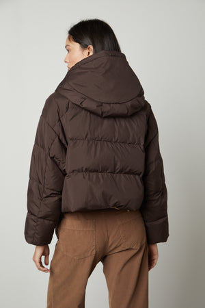 The back view of a woman wearing a Velvet by Graham & Spencer RAYLIN CROPPED PUFFER JACKET.