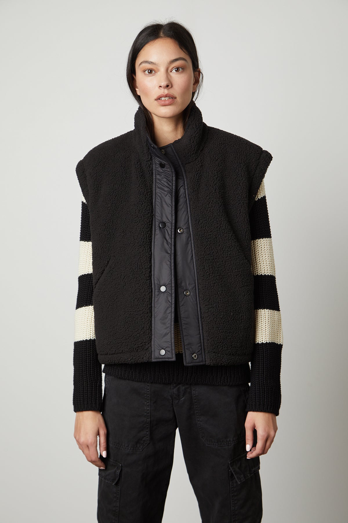 A woman wearing the Velvet by Graham & Spencer ALICIA REVERSIBLE PUFFER SHERPA VEST for cold weather.-35649878950081
