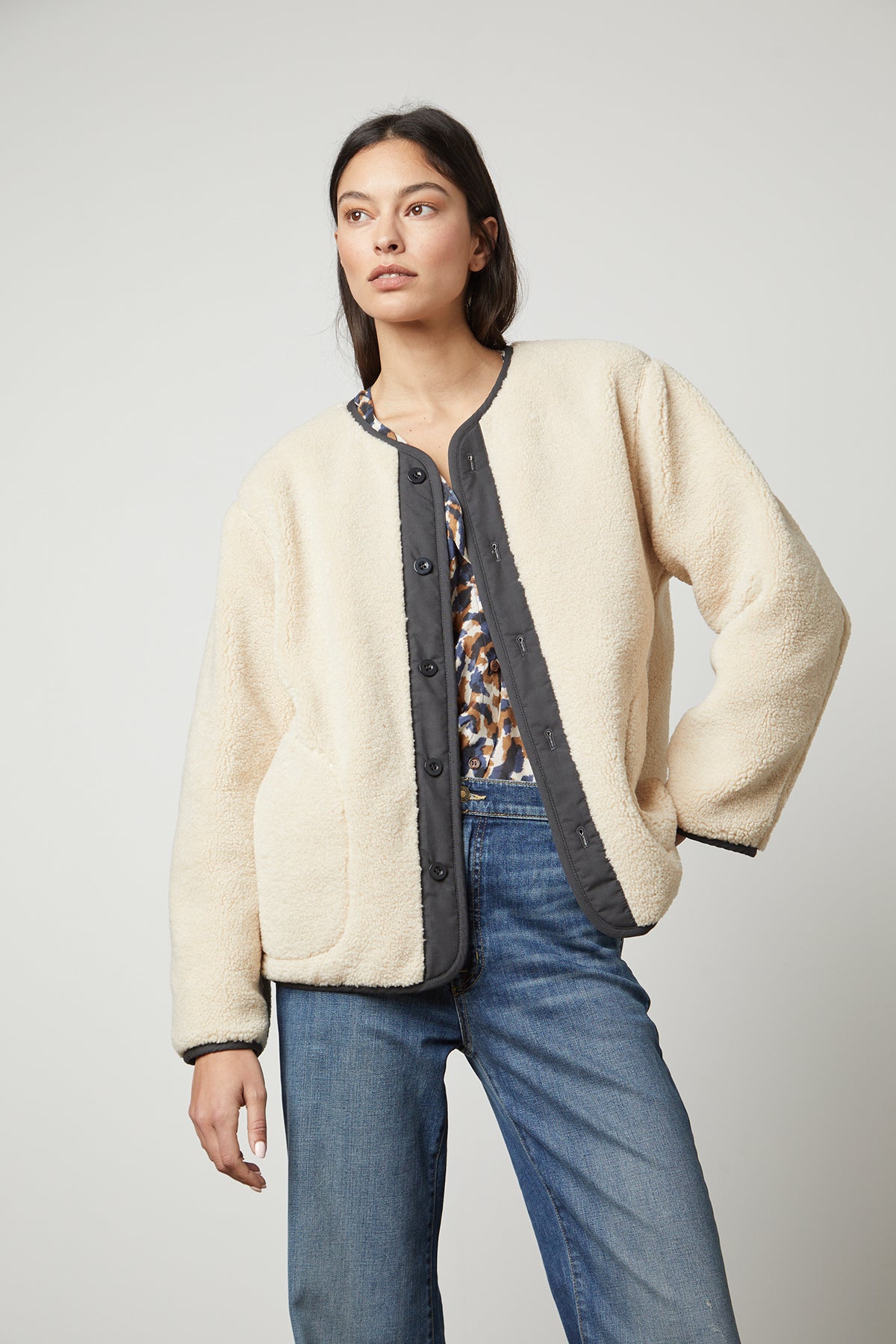 The model is wearing a cozy Velvet by Graham & Spencer Marissa Reversible Quilted Sherpa Jacket and jeans.