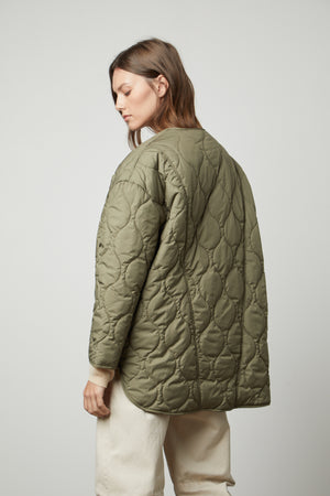 The back view of a woman wearing a Velvet by Graham & Spencer PAITYN QUILTED JACKET with quilted lining.