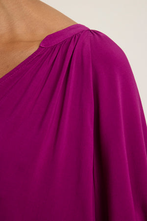 Close-up of a person wearing the LUNA TOP by Velvet by Graham & Spencer, featuring a magenta hue, relaxed fit, gathered shoulder detail, and a flattering V-neck.