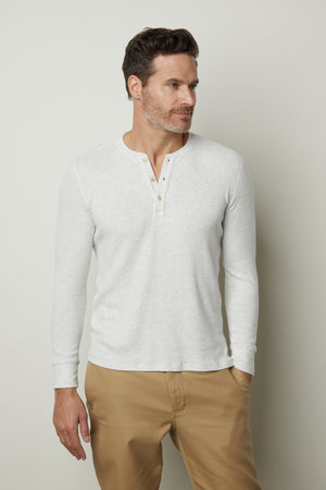 A man wearing a Velvet by Graham & Spencer Anderson Rib Knit Henley shirt and khaki pants.