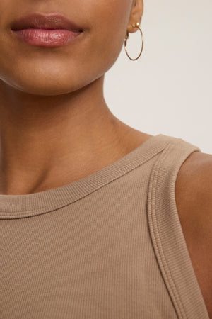 Close-up of a person wearing the AMELIA DRESS by Velvet by Graham & Spencer, with a gold hoop earring visible, highlighting their chin, lips, and part of their shoulder.