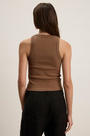 A person with long brown hair is shown from the back, wearing the SARI TANK TOP by Velvet by Graham & Spencer and dark pants against a neutral background.