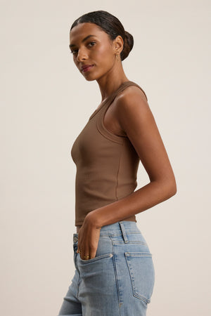 A person with dark hair in a low bun wears the Velvet by Graham & Spencer SARI TANK TOP in brown and light blue jeans, standing against a plain light background.