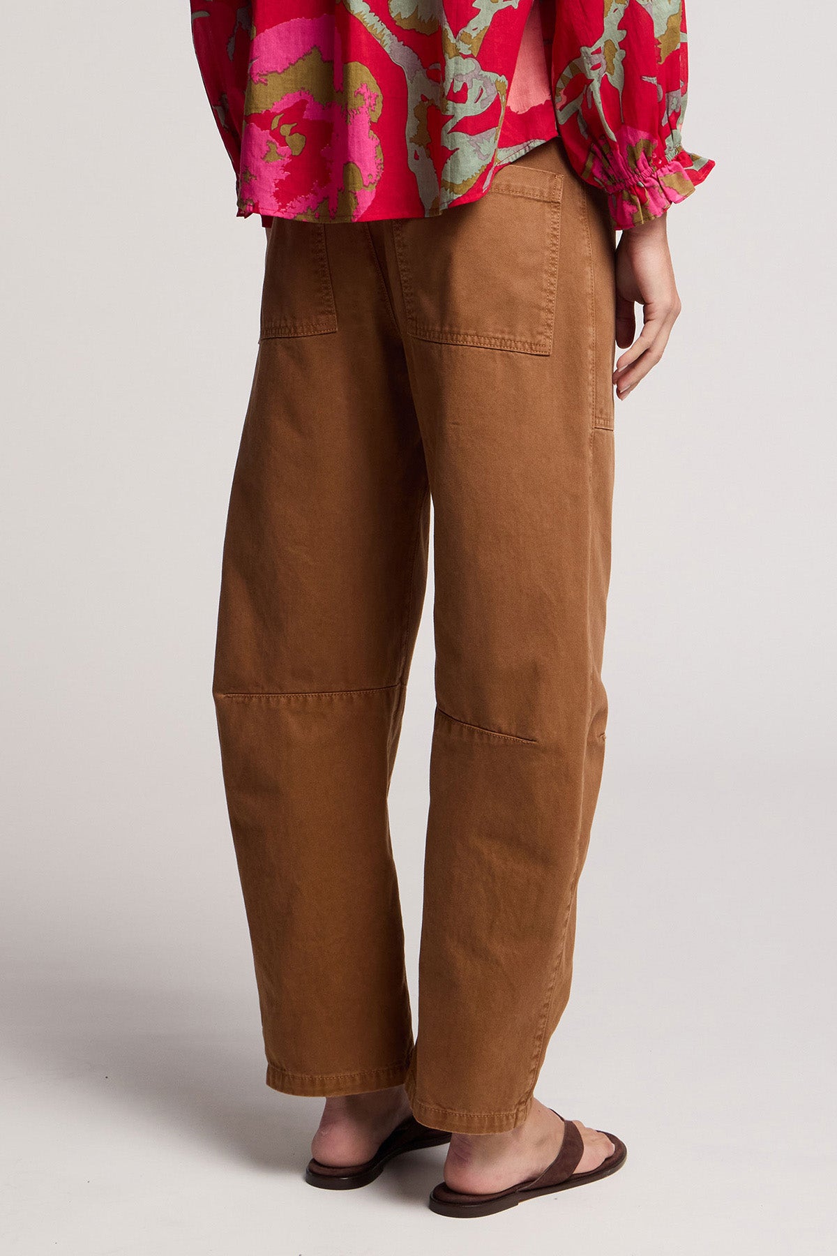 A person is seen from behind wearing the BRYLIE PANT by Velvet by Graham & Spencer, paired with a pink patterned top and sandals, standing against a plain background.-41371545895105