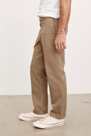 A man wearing Velvet by Graham & Spencer's TOBY SANDED TWILL PANT and white sneakers.