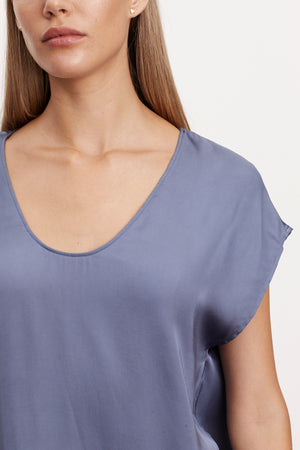 The model is wearing a KALI SATIN SCOOP NECK TOP by Velvet by Graham & Spencer.
