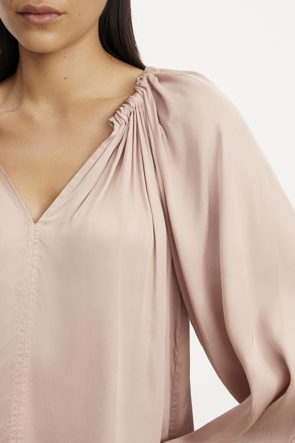 The model is wearing a Velvet by Graham & Spencer NORIA SATIN PEASANT TOP with a relaxed fit and ruffled sleeve.-35696181903553