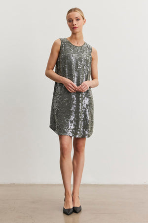 An individual wearing the KATHERINE SEQUIN DRESS by Velvet by Graham & Spencer poses against a plain white background.