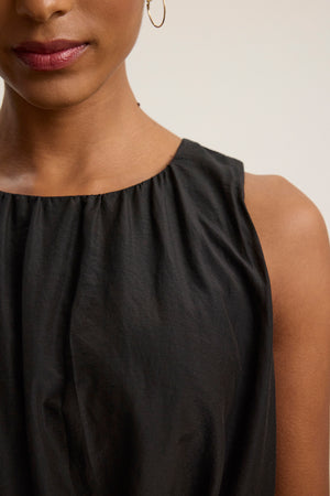 Close-up of a woman wearing the MARGOT SILK COTTON VOILE DRESS by Velvet by Graham & Spencer, with only the lower half of her face and upper torso visible, accessorized with a small hoop earring.
