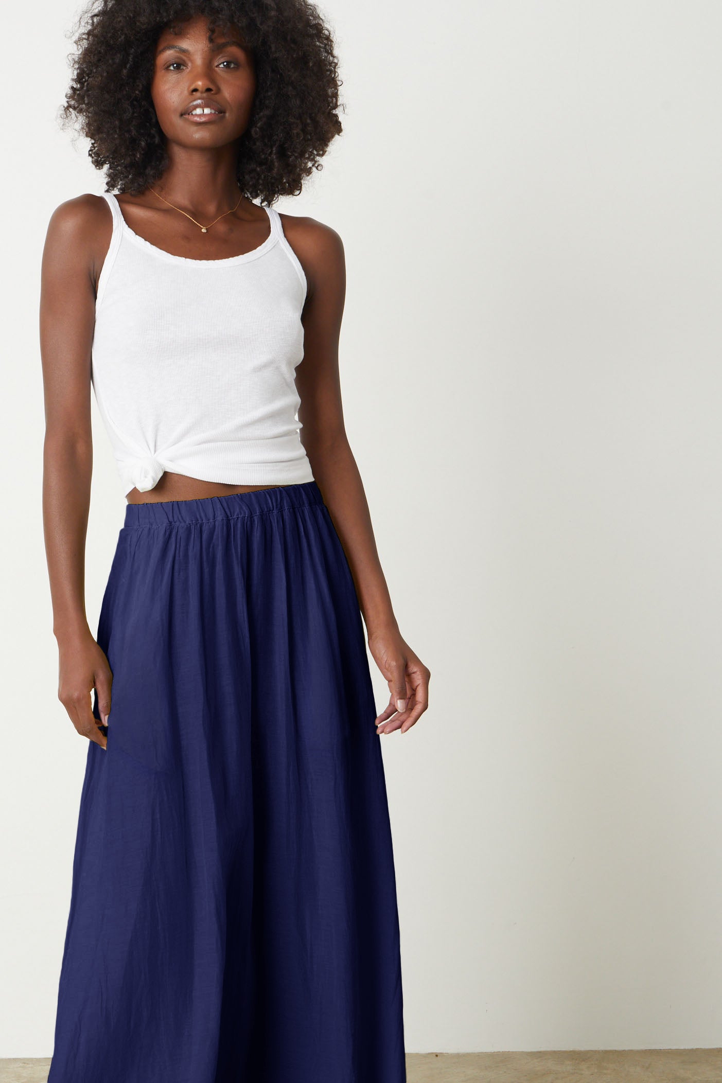 The model is wearing a Velvet by Graham & Spencer Mariela Maxi Skirt in cavern blue