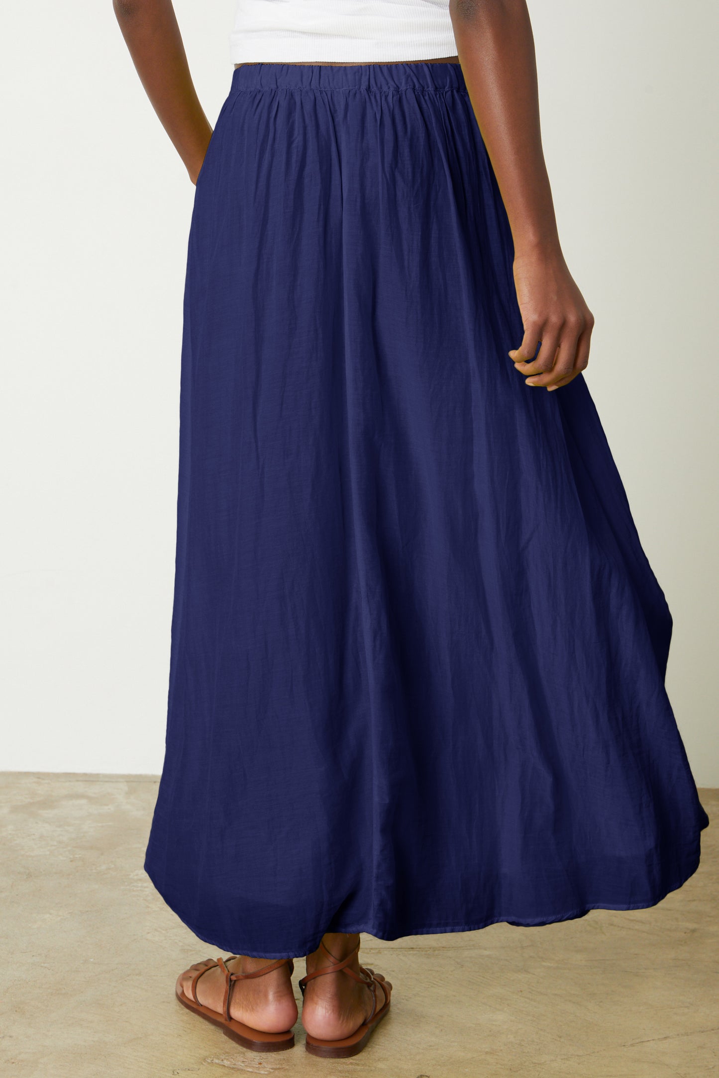 The back view of a woman wearing a Velvet by Graham & Spencer MARIELA MAXI SKIRT.-26577336926401