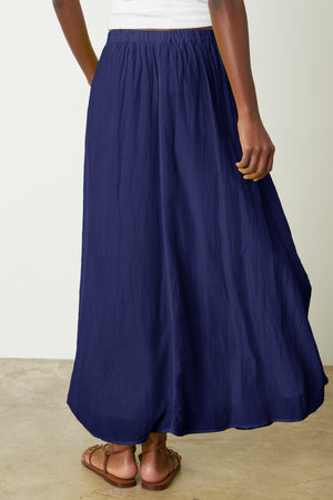 The back view of a woman wearing a Velvet by Graham & Spencer MARIELA MAXI SKIRT.
