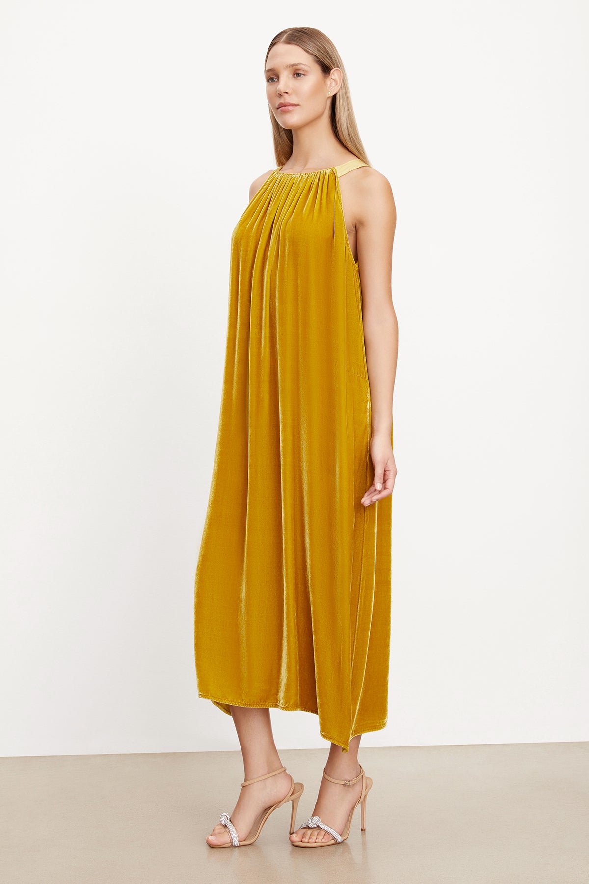 The model is wearing a MAREN SILK VELVET HALTER DRESS by Velvet by Graham & Spencer.