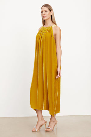 The model is wearing a MAREN SILK VELVET HALTER DRESS by Velvet by Graham & Spencer.