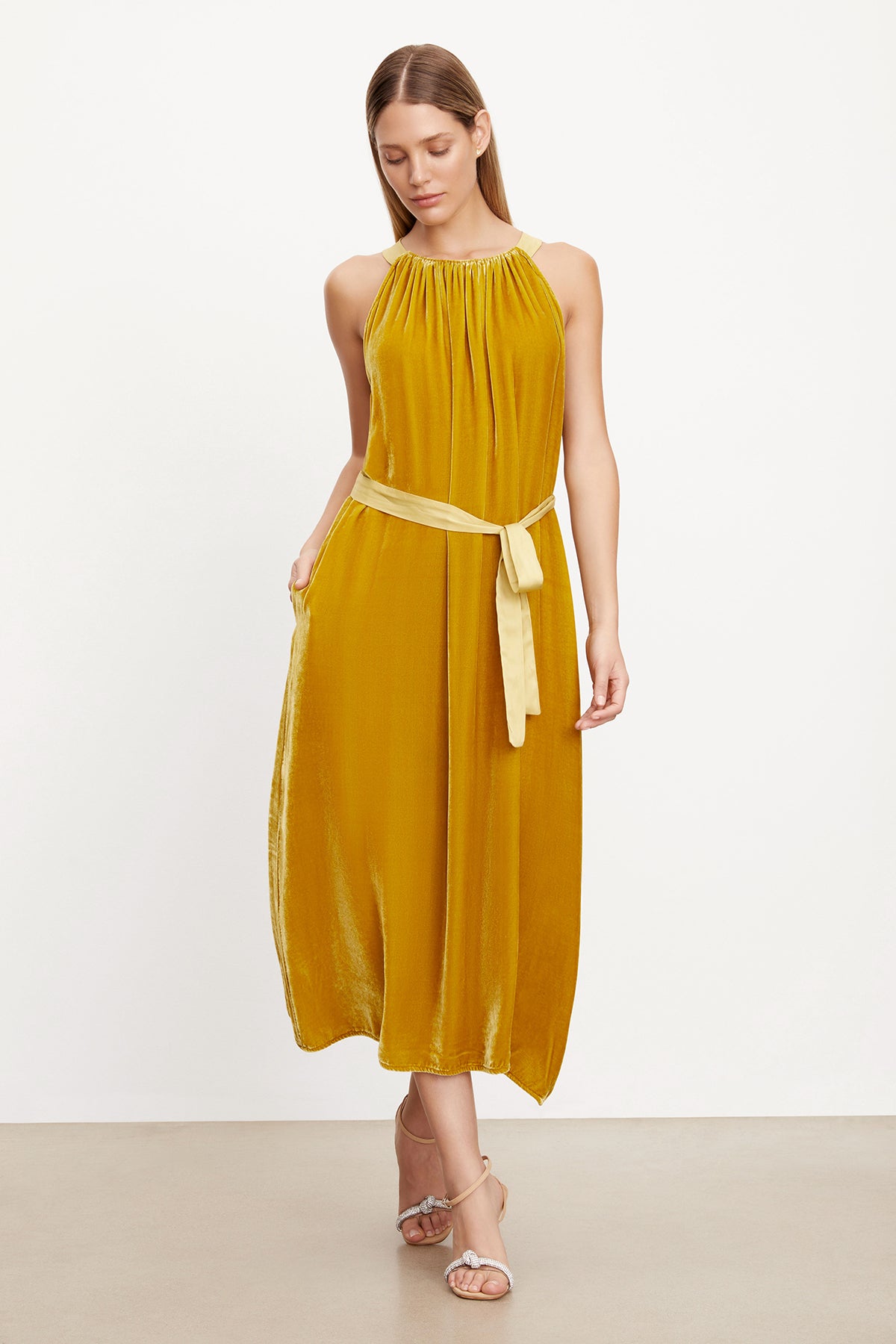A woman wearing a MAREN SILK VELVET HALTER DRESS by Velvet by Graham & Spencer.