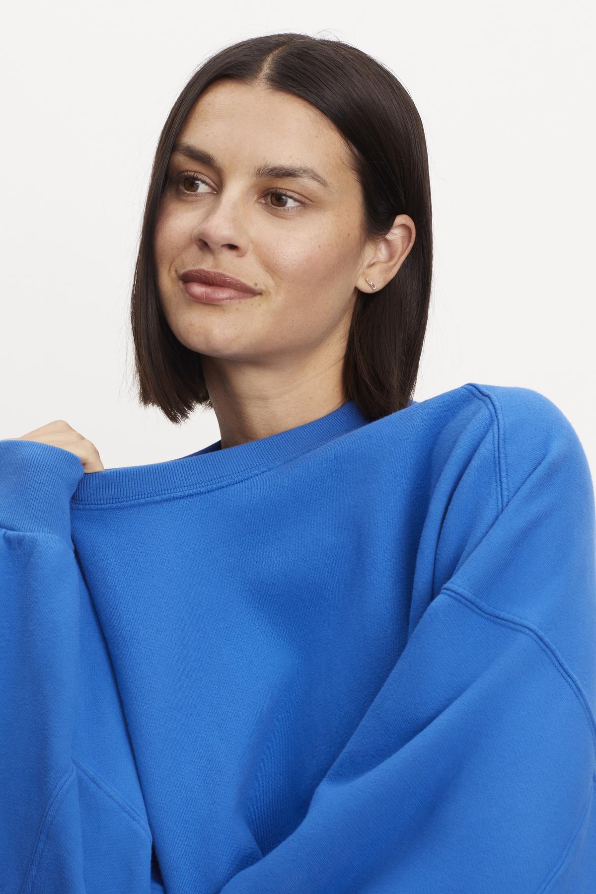 A model wearing the Velvet by Graham & Spencer Margot Oversized Sweatshirt in soft fleece.-35961316147393