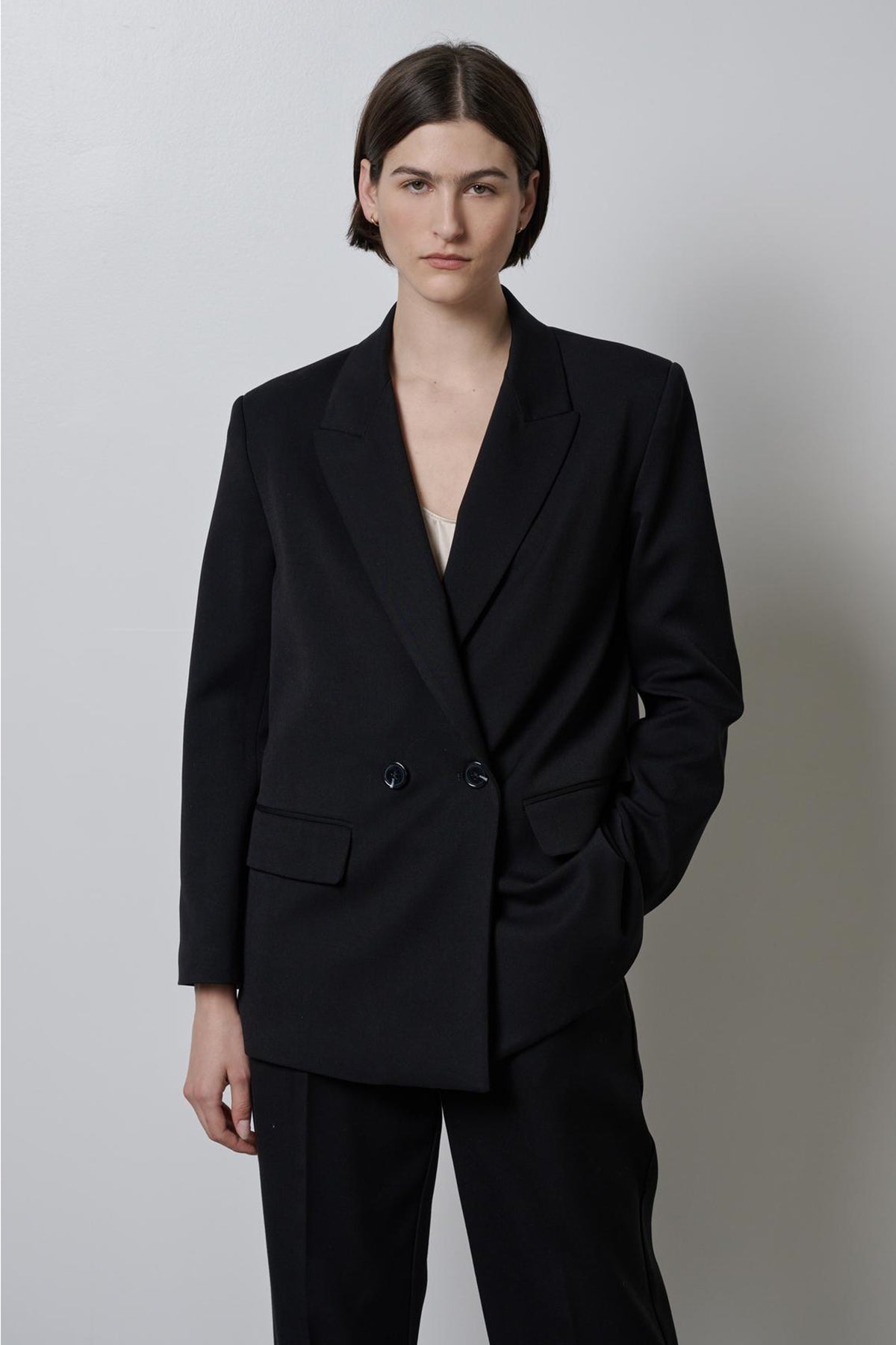 A person posing in a Velvet by Jenny Graham Fairfax blazer and trousers.-35995794014401