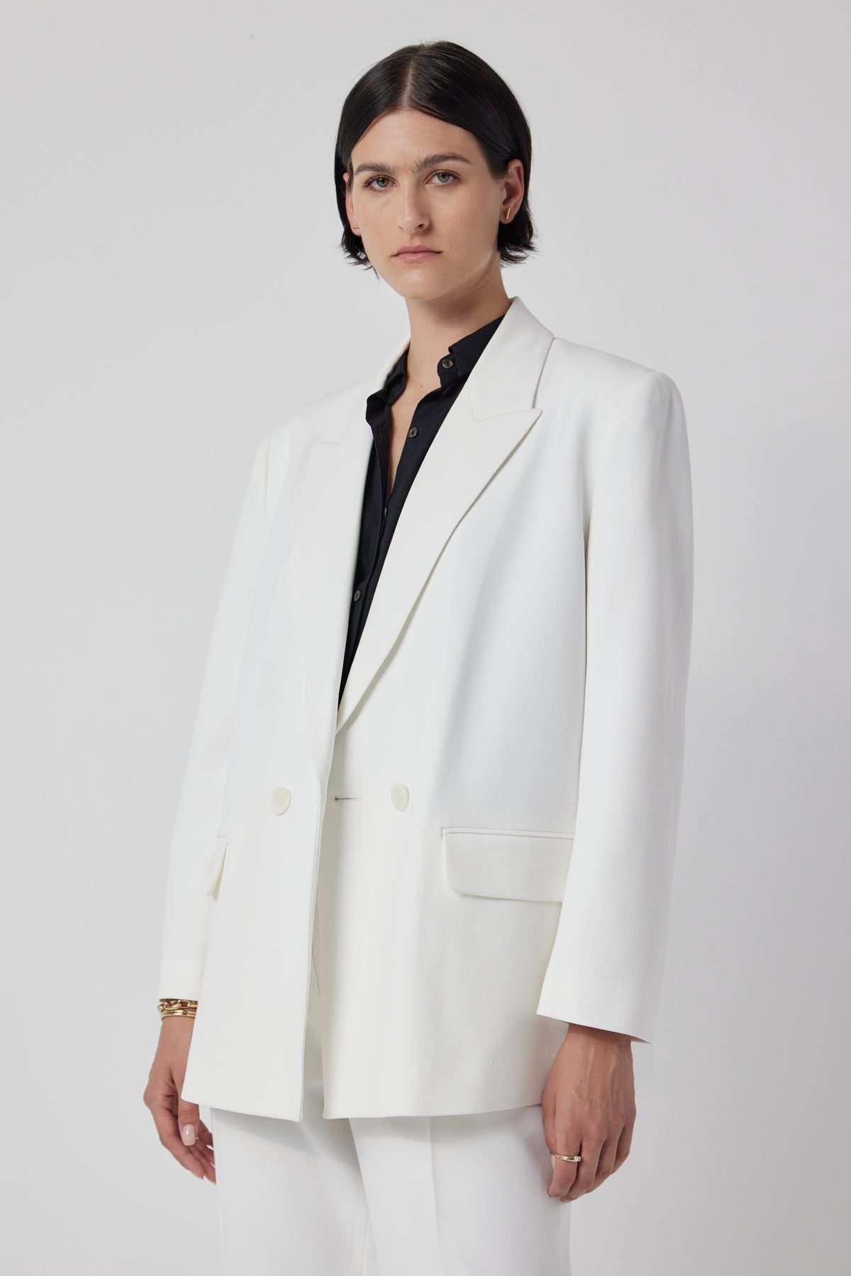   A woman wearing a white Fairfax blazer by Velvet by Jenny Graham. 