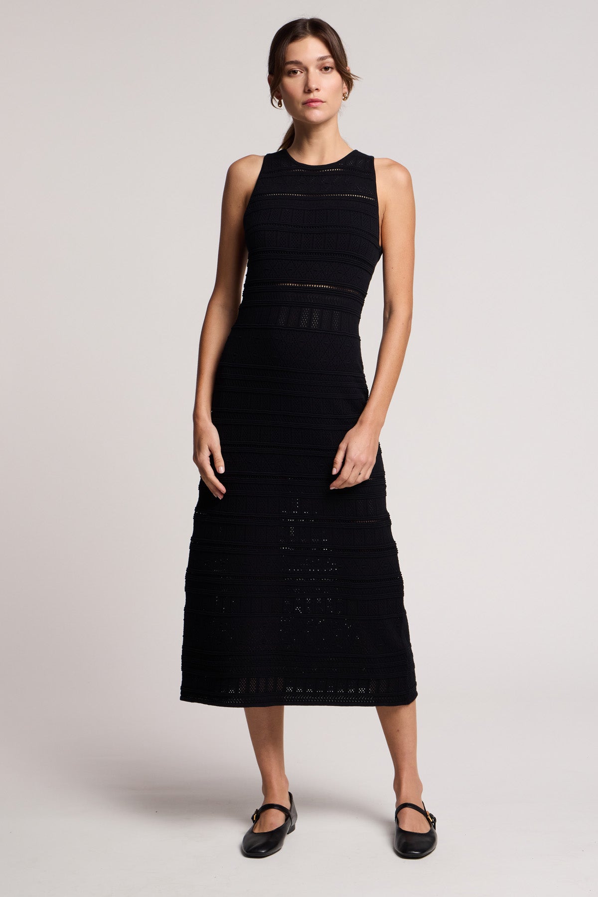 A woman wears the YLENA DRESS by Velvet by Graham & Spencer, a sleeveless textured midi in a fitted A-line silhouette, paired with black Mary Jane shoes against a plain light background.-41645207650497