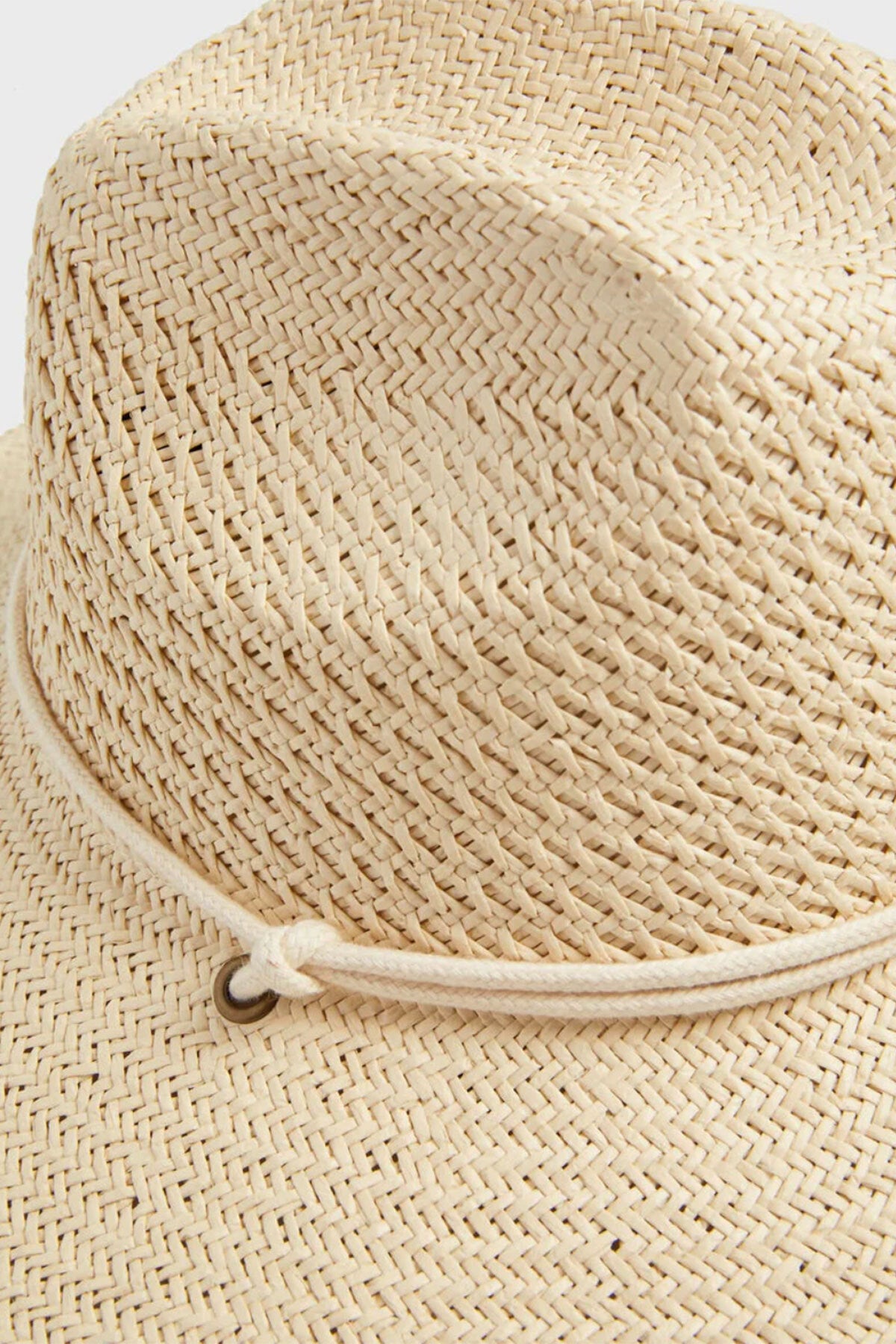 Close-up of the SURFER HAT by Velvet by Graham & Spencer, featuring a woven paper straw design, a thin rope band with a metal ring detail, and a cotton cord chinstrap for secure wear.-39190452535489