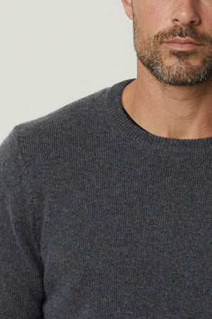 A Velvet by Graham & Spencer DASHELL CREW NECK SWEATER in grey, showcasing both warmth and style, worn by a bearded individual.