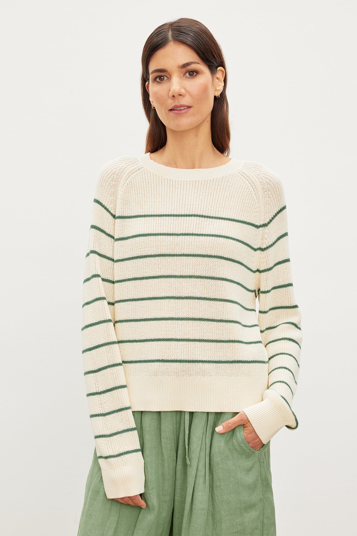 The model is wearing a Velvet by Graham & Spencer CHAYSE STRIPED CREW NECK SWEATER made of textured cotton.-35955537019073