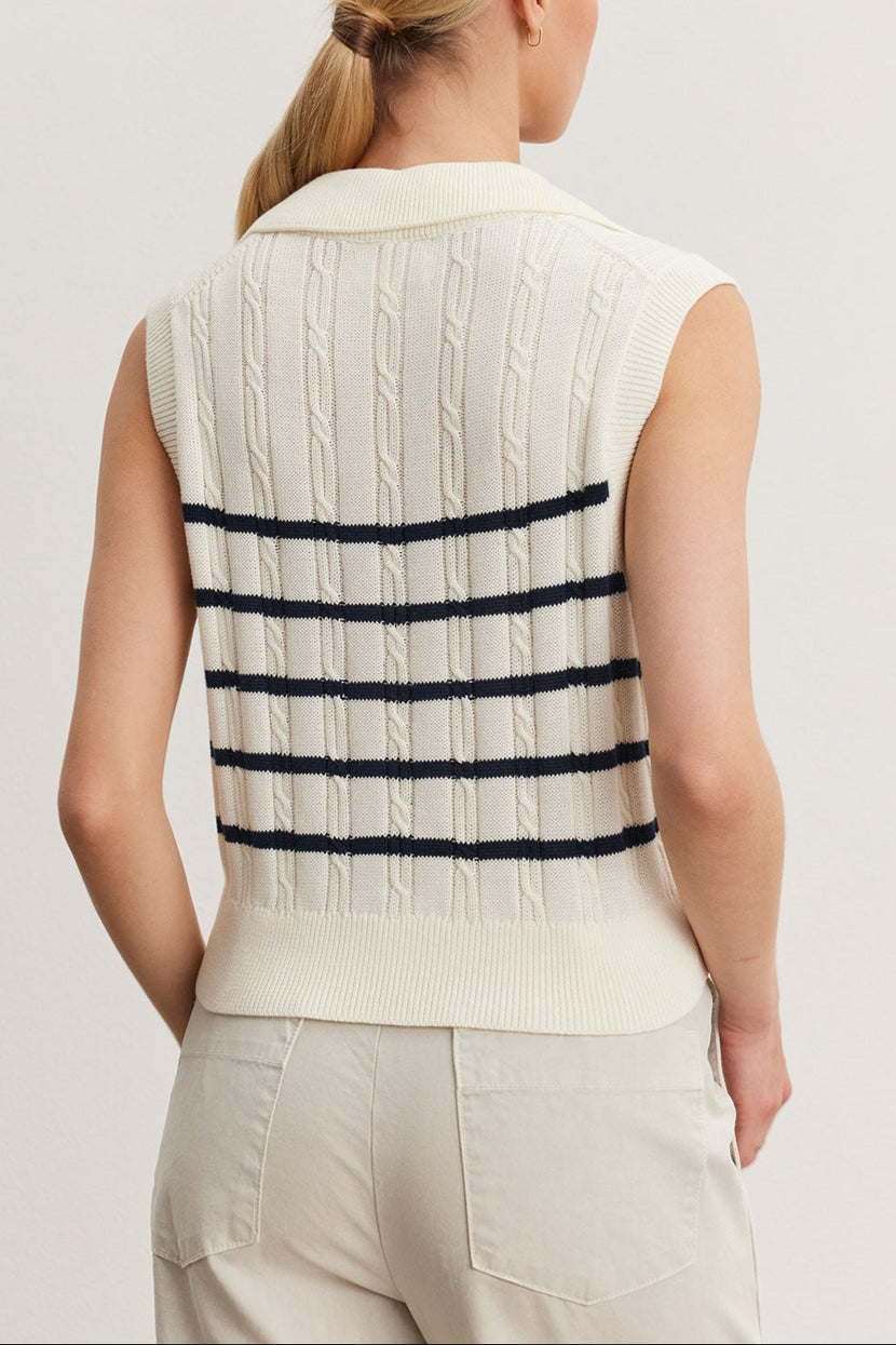 Woman viewed from behind, wearing a white Velvet by Graham & Spencer WENDY SWEATER VEST with horizontal black stripes, paired with beige pants.