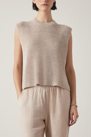 A person with short dark hair is wearing the Velvet by Jenny Graham's GARDENA LINEN SWEATER VEST and light brown relaxed fit pants, standing against a plain background.
