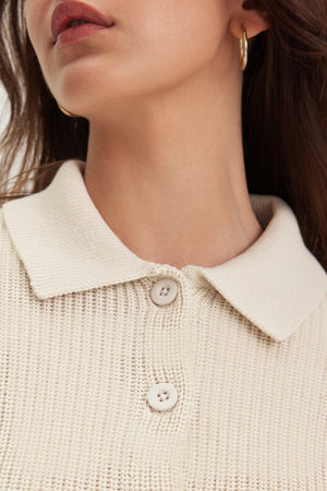 Close-up of an individual wearing the TAJ CARDIGAN by Velvet by Graham & Spencer with gold hoop earrings, enhancing a modern silhouette.