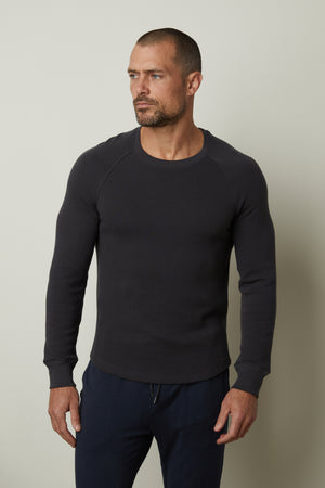 A man wearing a Velvet by Graham & Spencer black sweatshirt, comfortable fit.