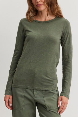 A person with long hair wears a LIZZIE TEE by Velvet by Graham & Spencer in green, complete with long sleeves and matching pants, standing against a plain background.