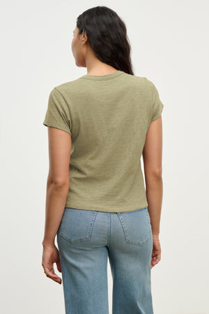A person with long dark hair is seen from behind wearing the Velvet by Graham & Spencer MARIE TEE in a relaxed boxy fit, paired with light blue jeans.