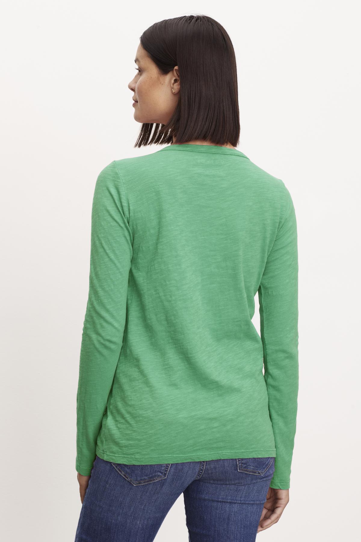The back view of a woman wearing a Velvet by Graham & Spencer LIZZIE ORIGINAL SLUB LONG SLEEVE TEE made of cotton fabric.-36320822952129